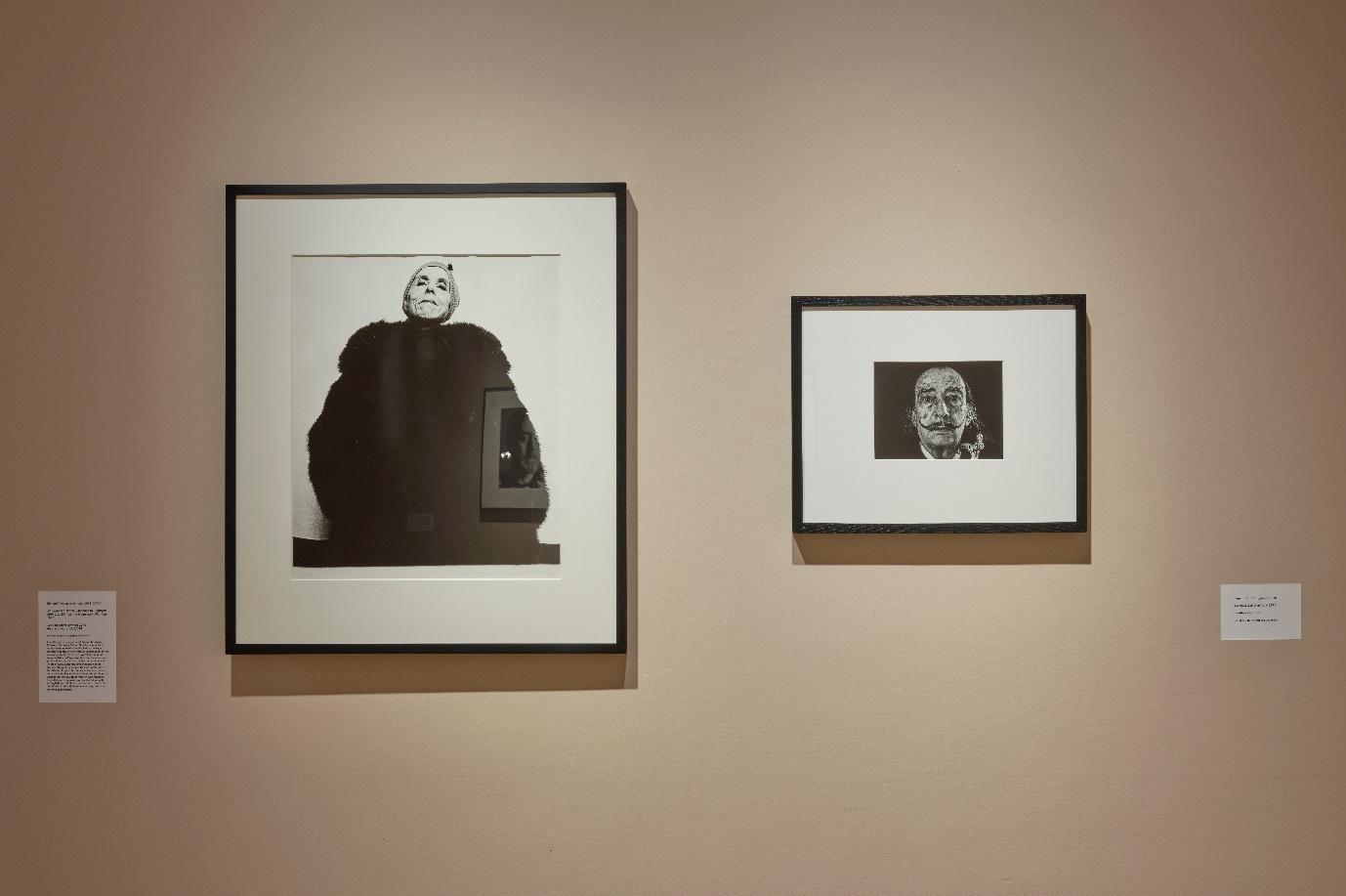 Gallery wall featuring two black and white portraits; one larger, dramatic portrait on the left and a smaller close-up portrait on the right.